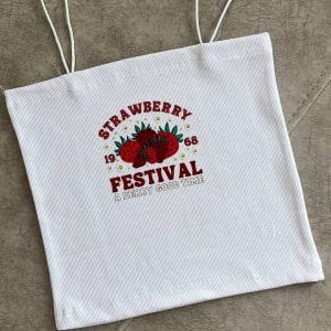 کراپ تاپ بند ماکارون رنگ سفید با طرح توت فرنگی و نوشته فستیوال به انگلیسی دارای بند ماکارون نمای دور از جلو