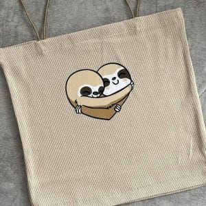 تاپ کراپ زنانه با طرح دو تنبل کارتونی که یکدیگر را در آغوش گرفته اند و شکلی شبیه قلب را تشکیل داده اند