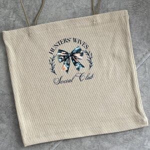 تاپ کراپ زنانه با طرح 'HUNTERS' WIVES Social Club' و پاپیون گلدار در مرکز